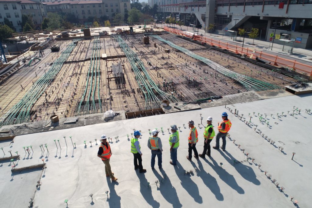 Workers standing at a large construction site